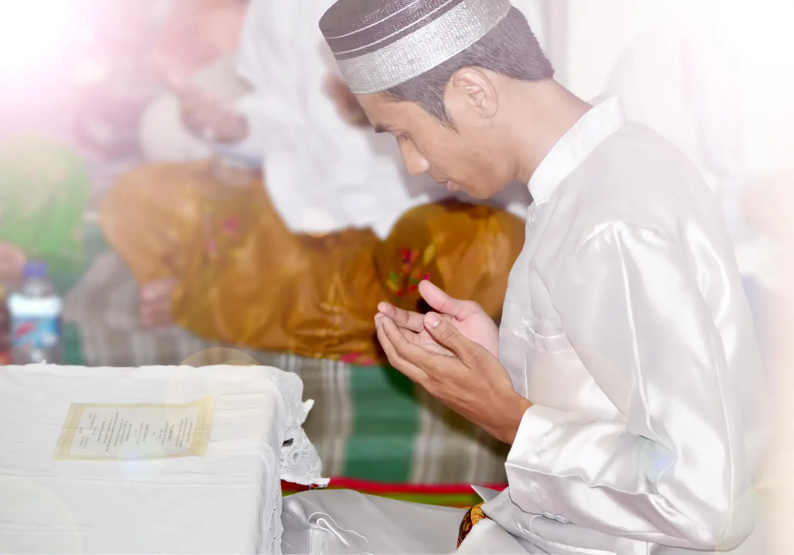 Man praying during a family celebration with soft balloons behind