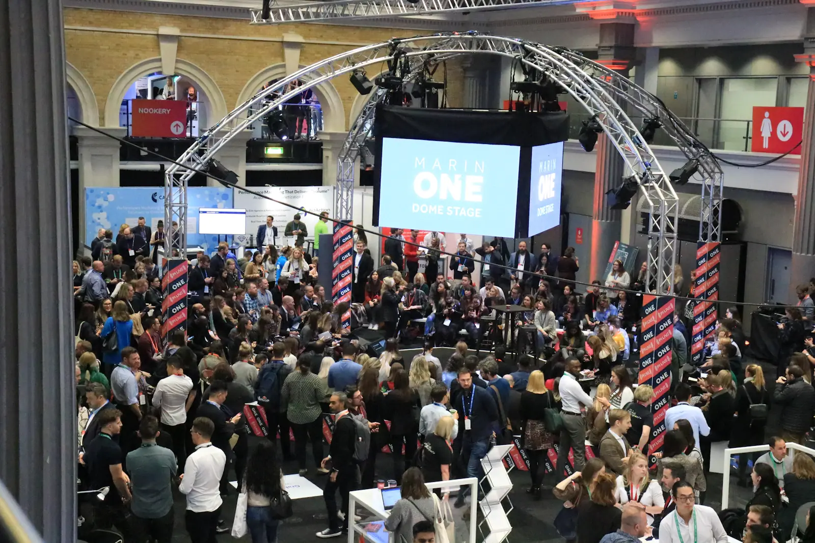 Large exhibition hall event with a stage and crowd