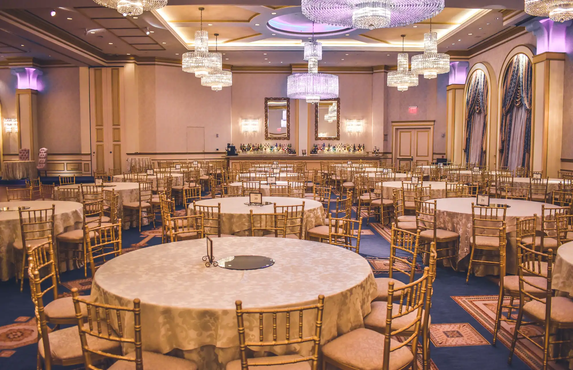 Elegant gala ballroom with round tables and crystal chandeliers