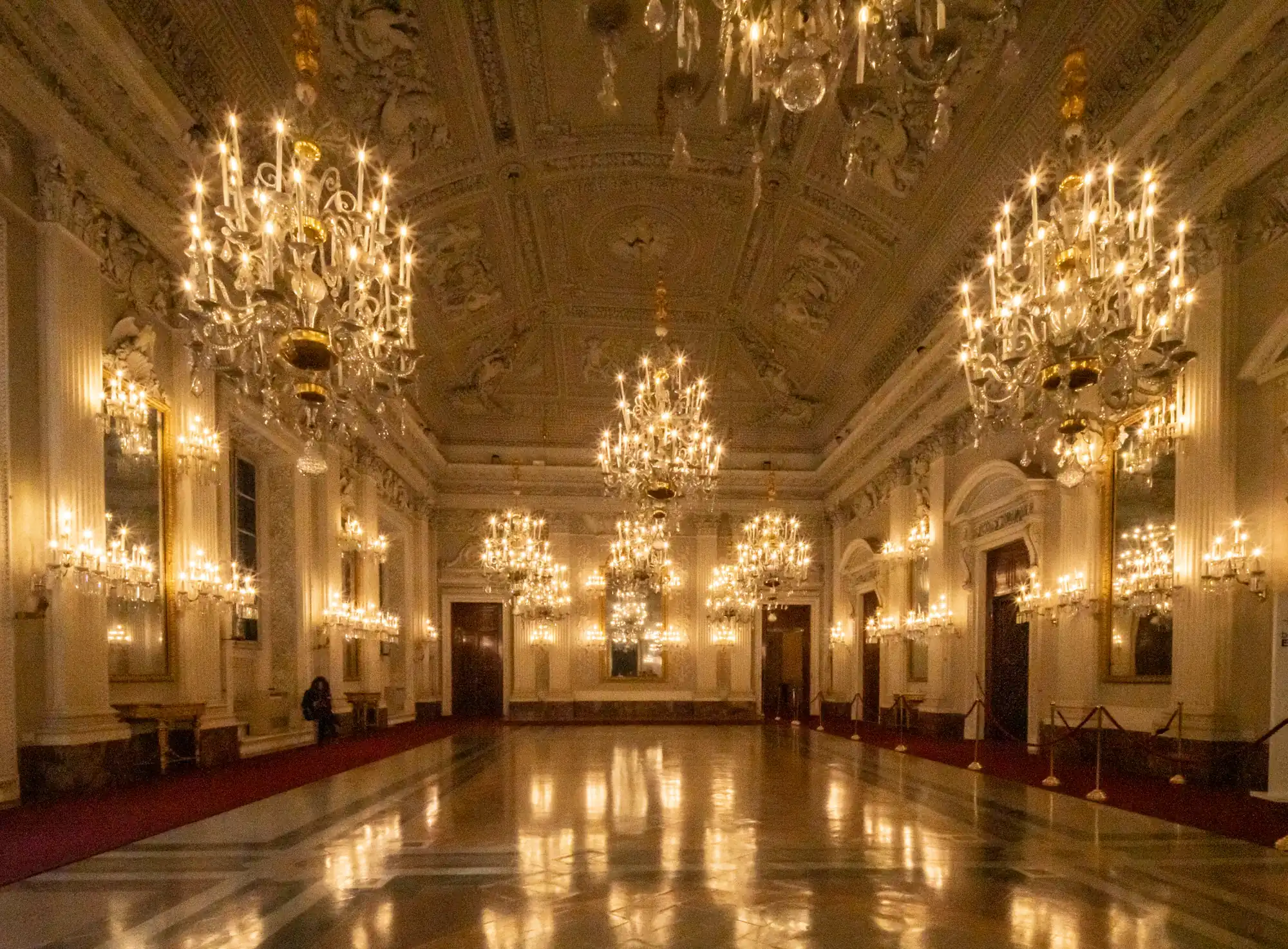 Luxury ballroom with gold chandeliers and polished floor