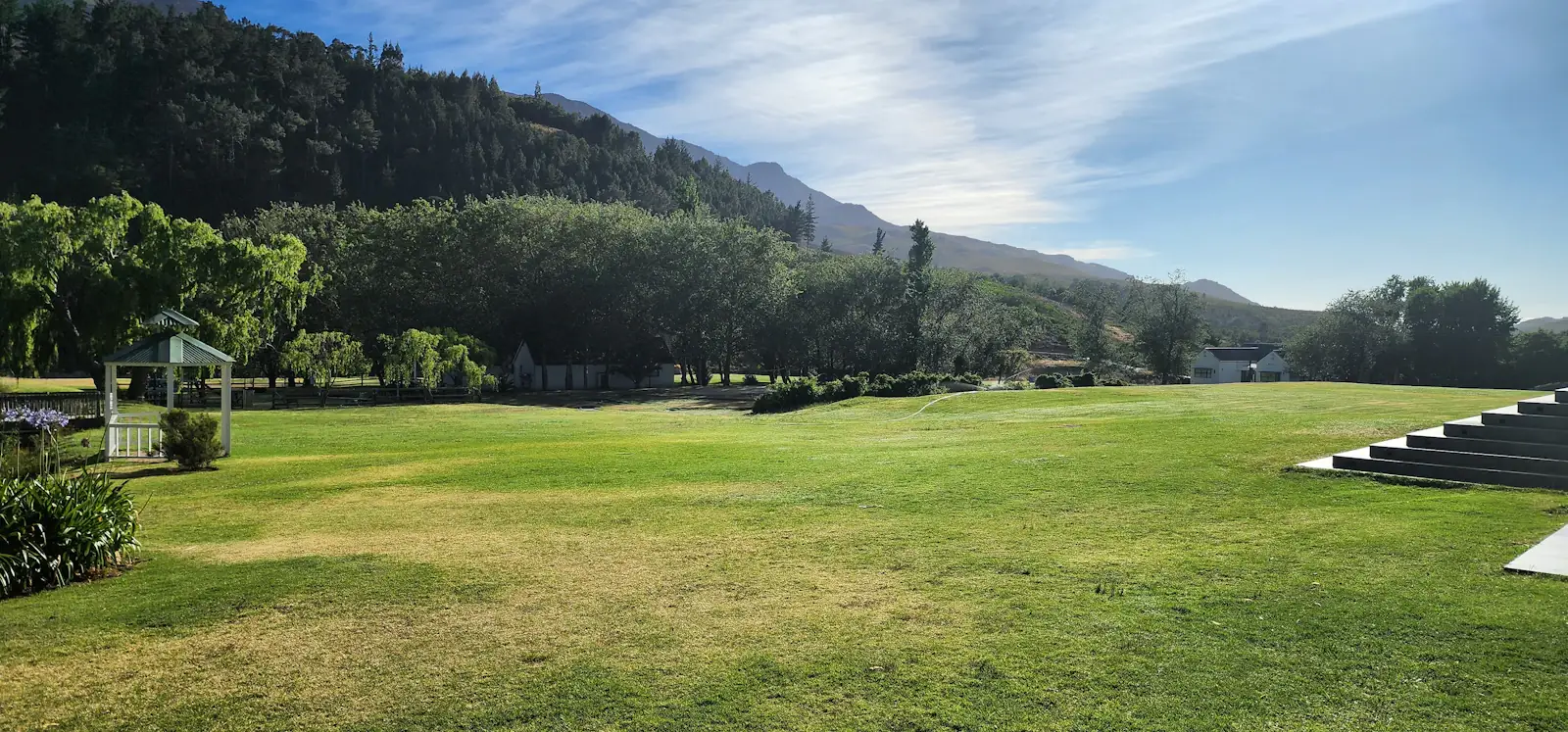 Open green lawn venue with mountains in the background
