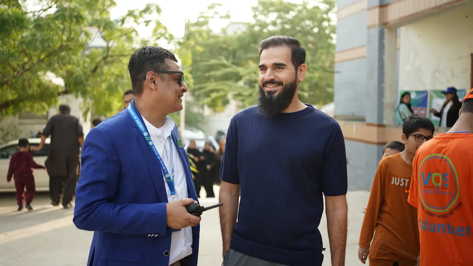 Two people talking at an event, one wearing a blue blazer